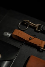 Close-up of leather cuffs and chains resting on a dark velvet surface.