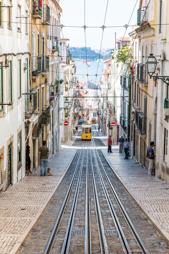 people walking on sidewalk between buildings during daytime in Santa Bica Portugal