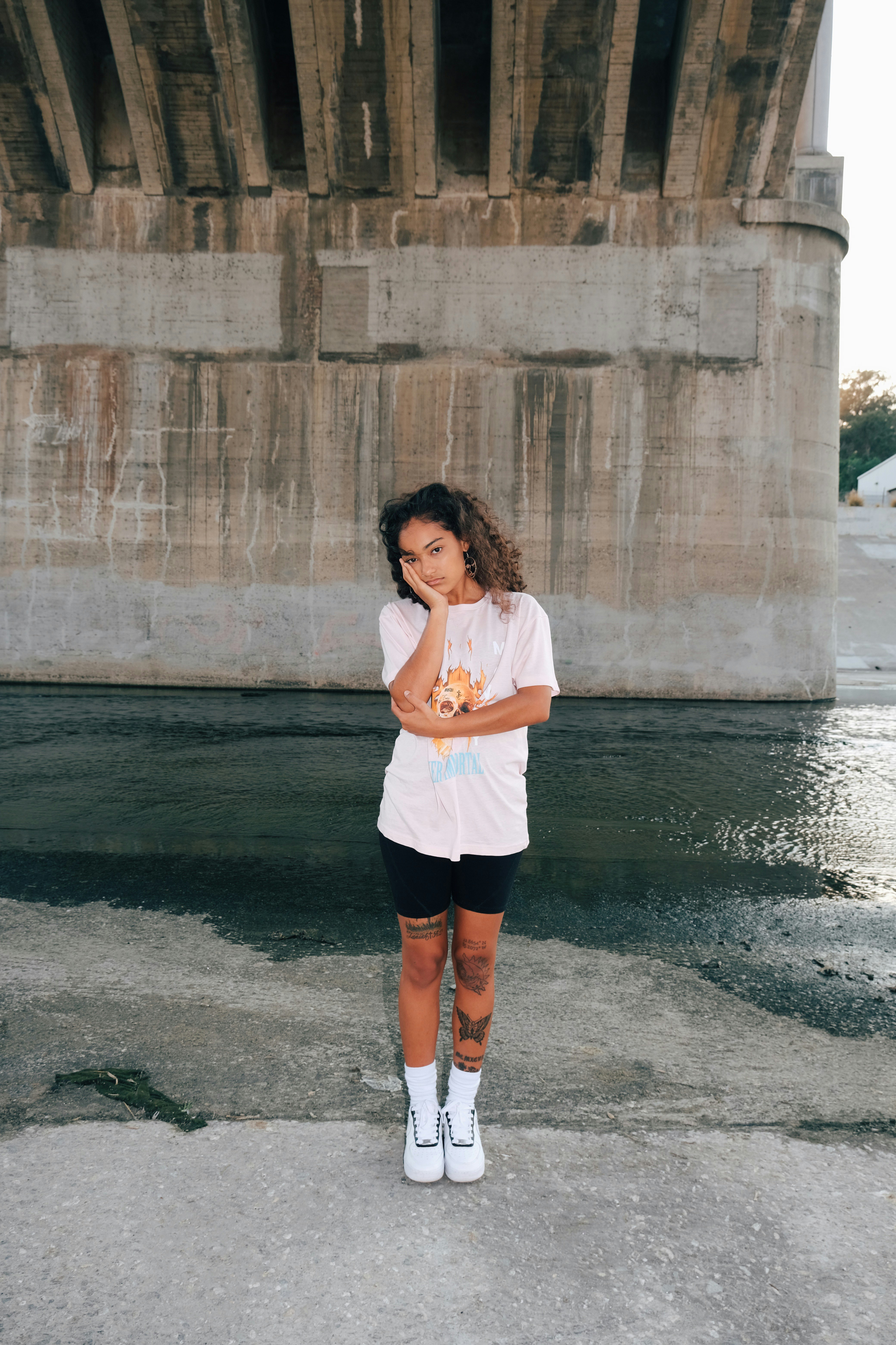 woman in white shirt and black shorts standing on water