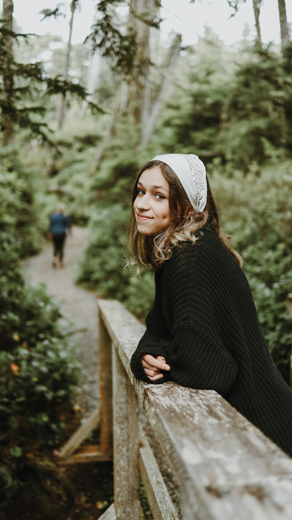 woman in black sweater and white cap