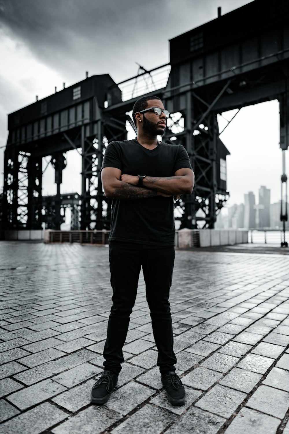 man in black crew neck t-shirt and black pants standing on gray concrete floor