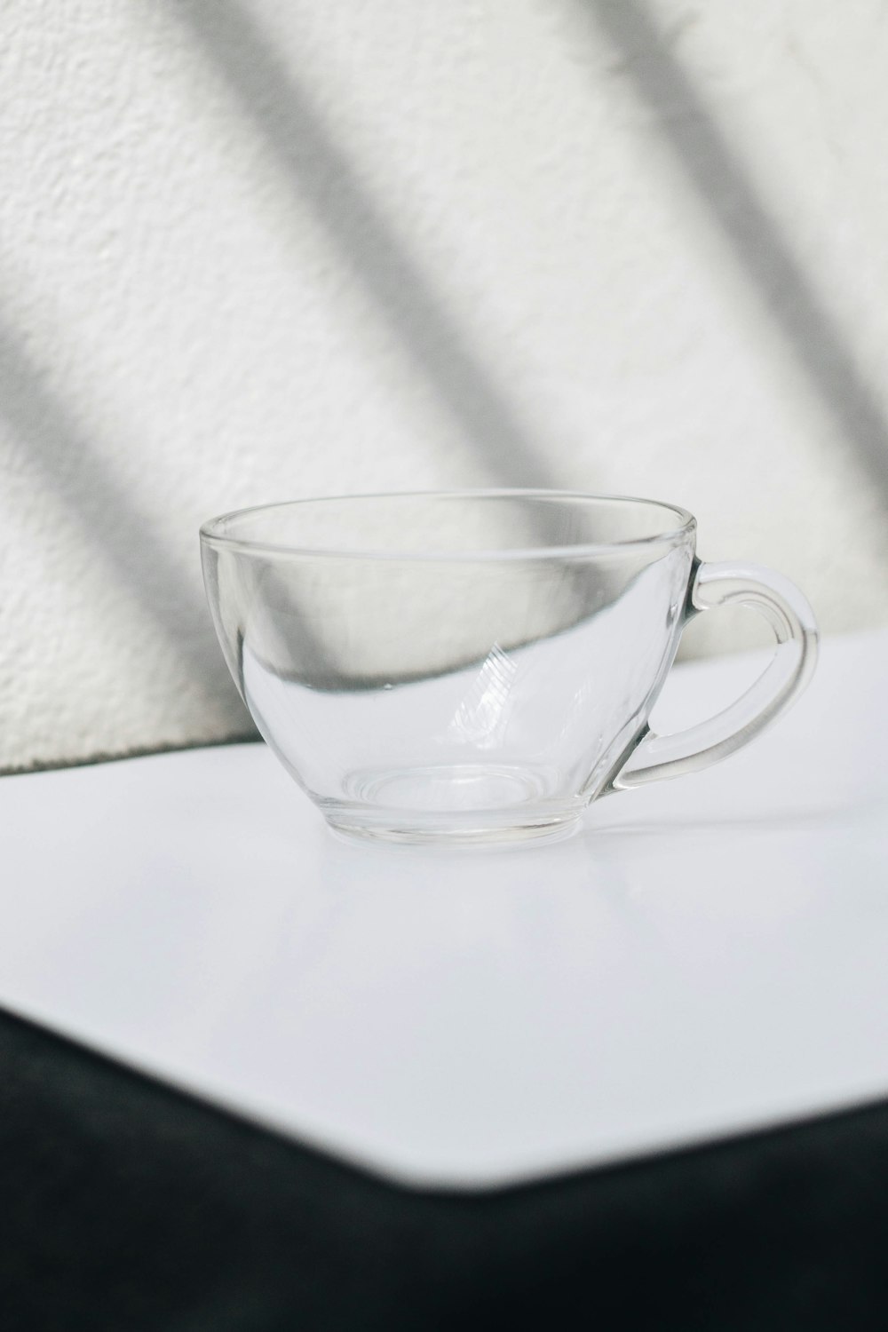 clear glass cup on white table