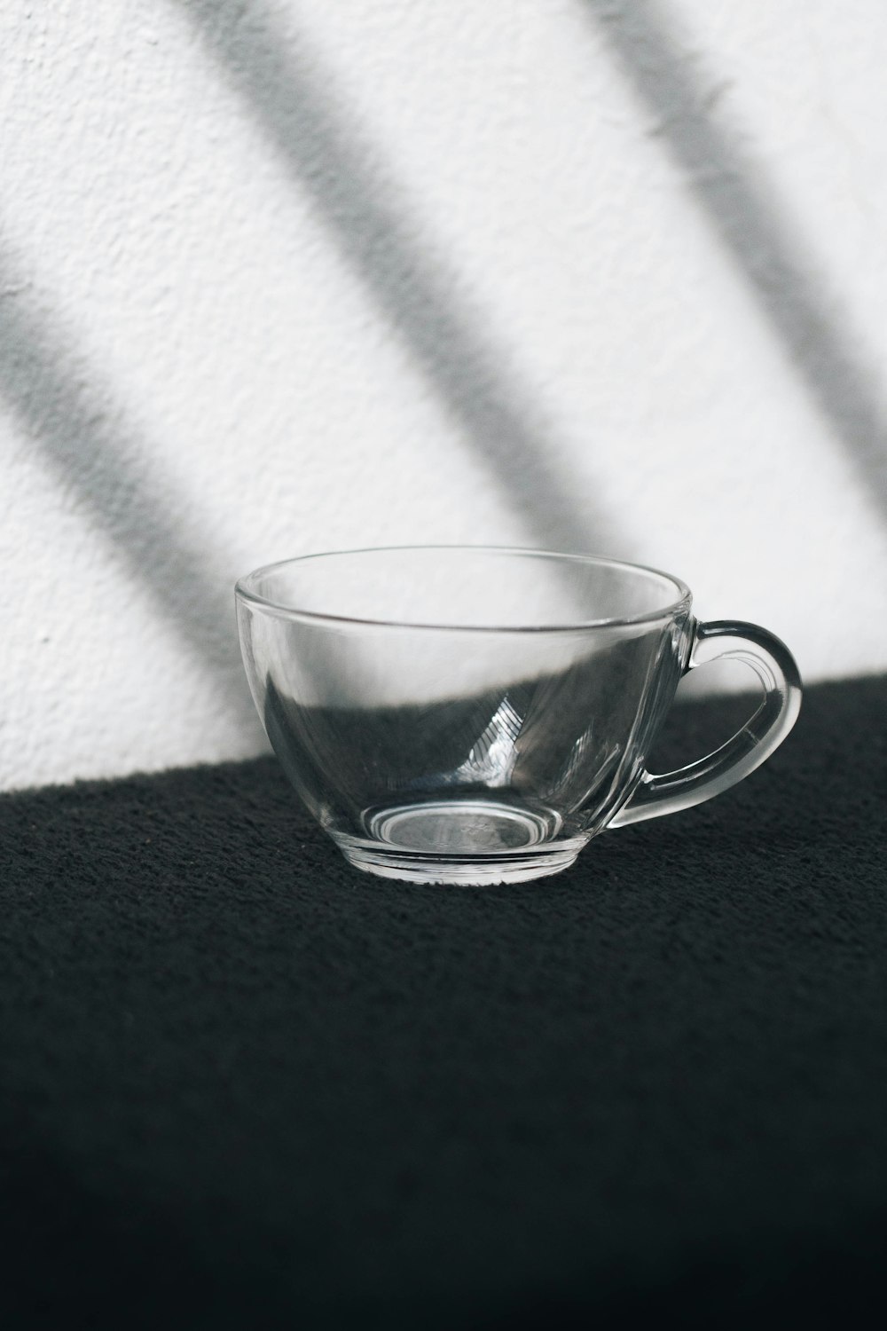 clear glass cup on black textile