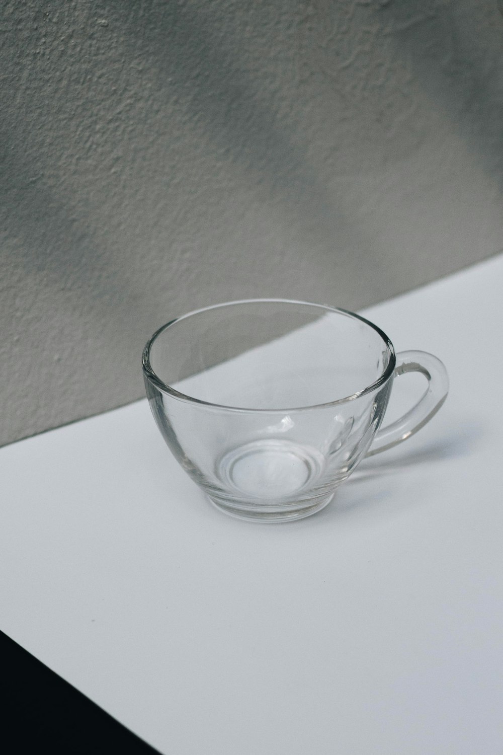 clear glass cup on white table