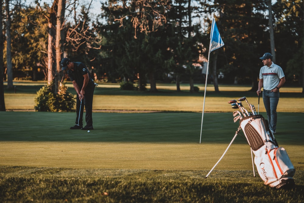 man in black shirt and black pants playing golf during daytime