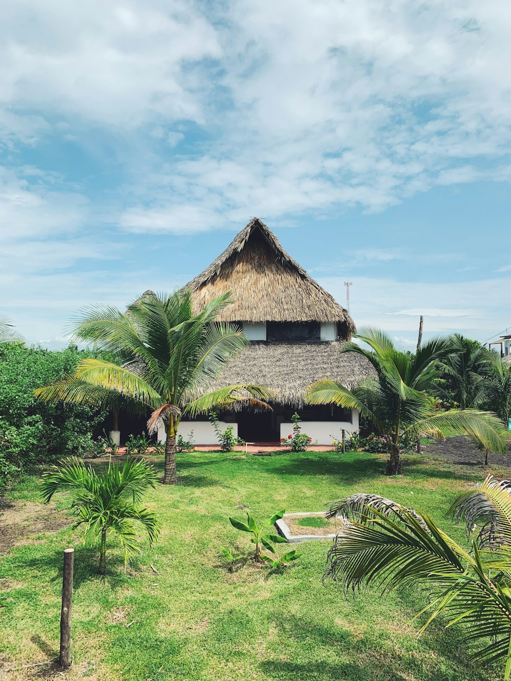 Casa de madera marrón cerca de campo de hierba verde bajo el cielo azul durante el día