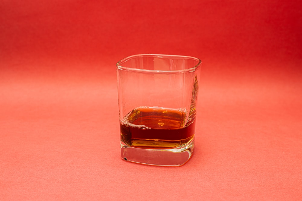 clear shot glass with brown liquid