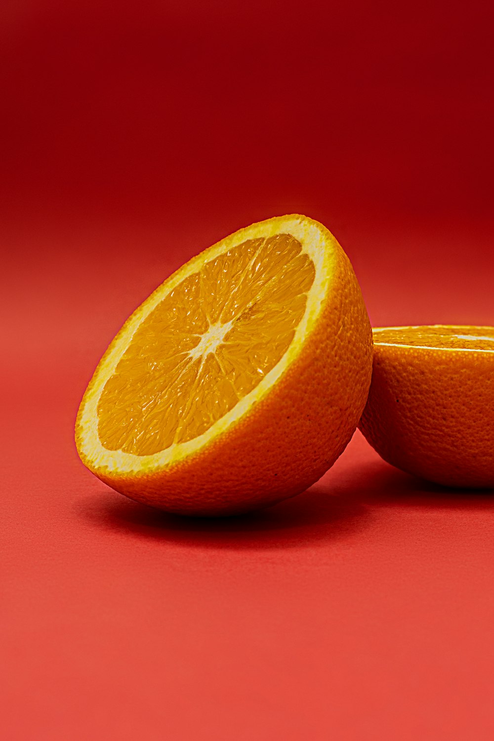 sliced orange fruit on red surface