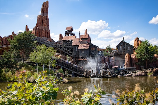 water fountain near brown concrete building during daytime in Disneyland Park, Big Thunder Mountain Railroad France