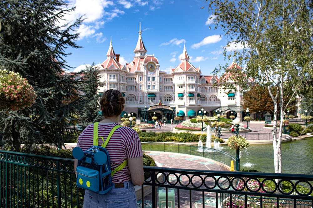 man in green shirt sitting on green chair near fountain during daytime