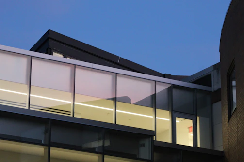 A stunning modern apartment building with large glass windows reflecting the evening sky.