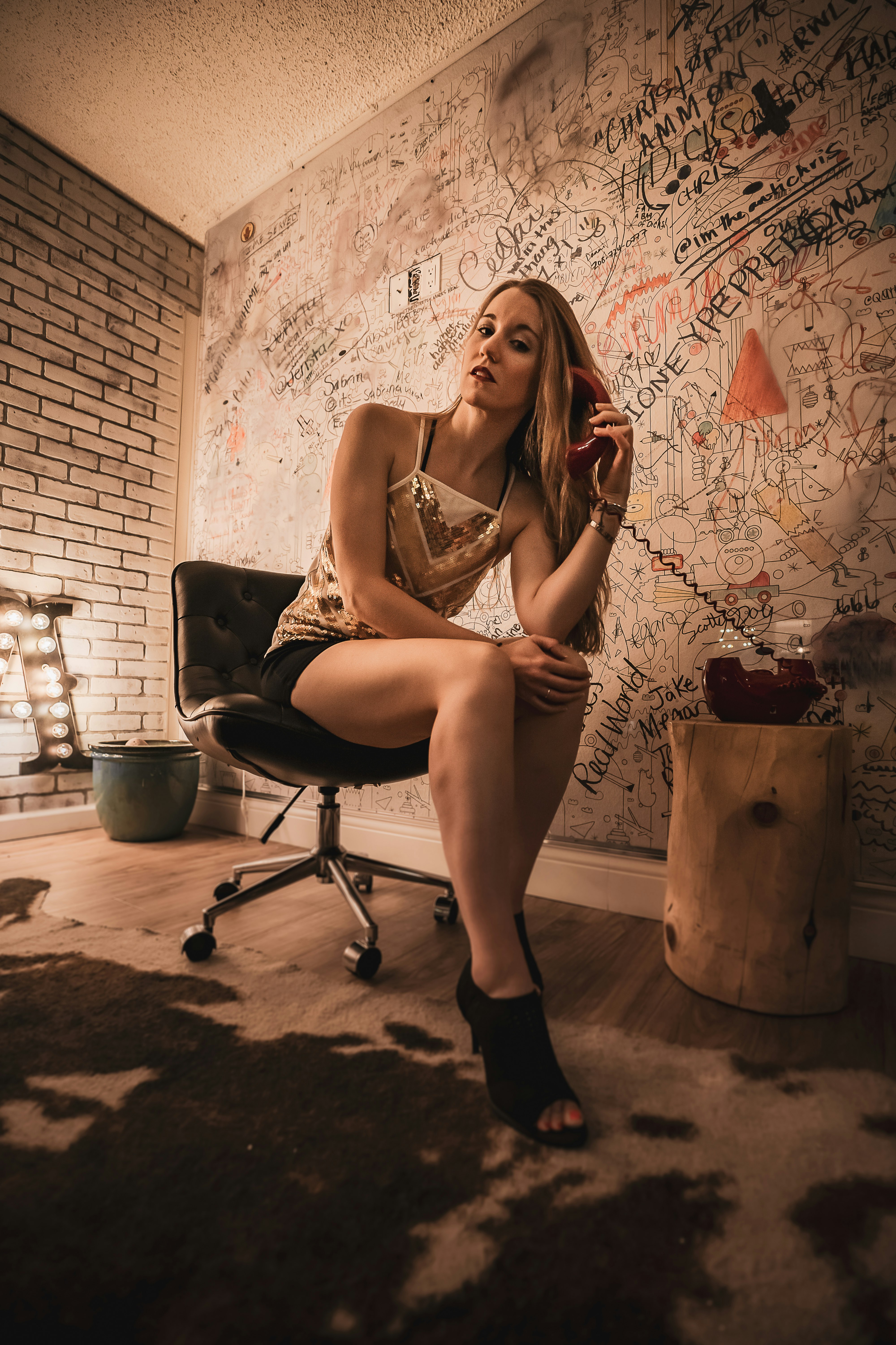 woman in white and black spaghetti strap dress sitting on black office rolling chair