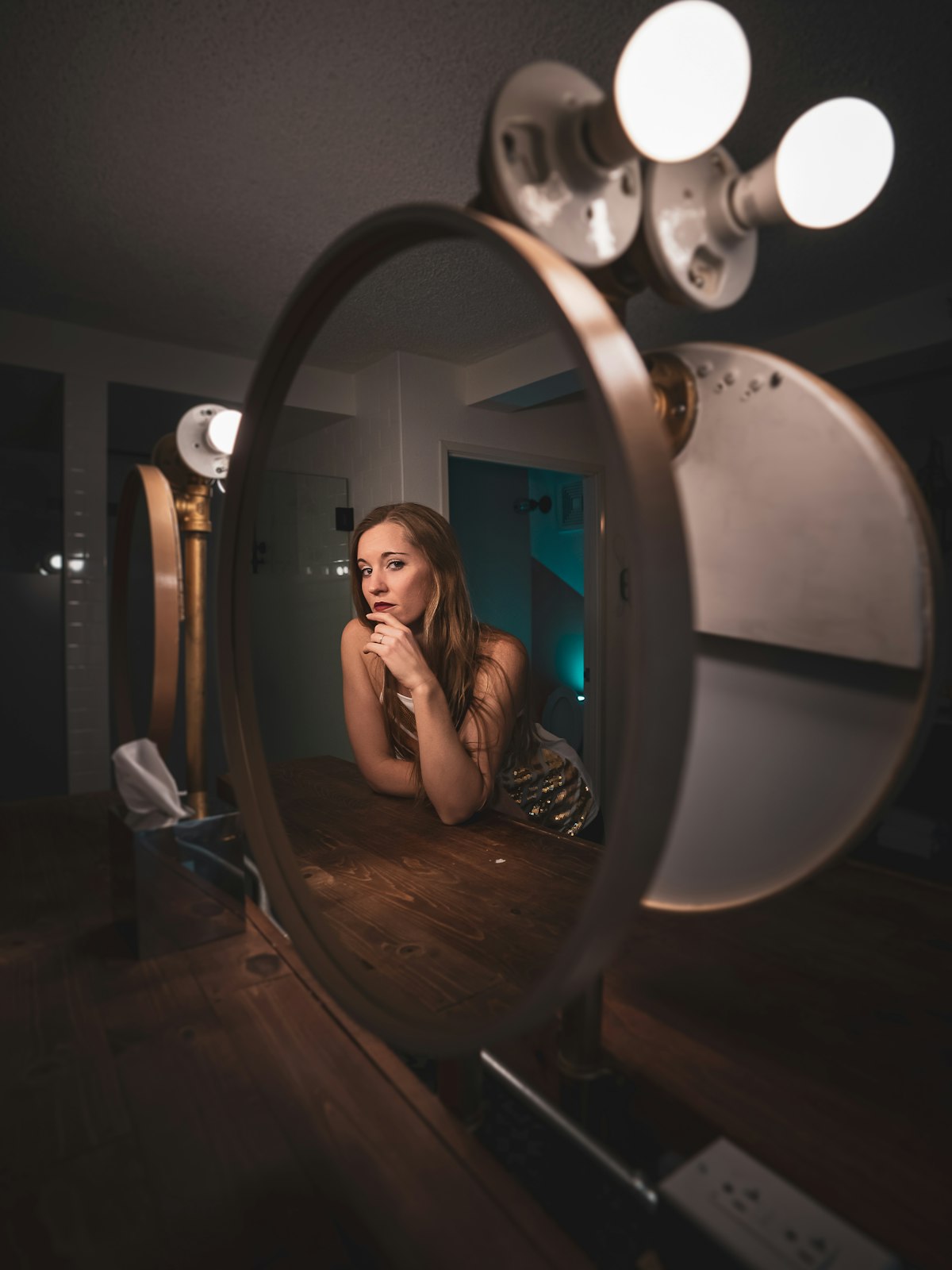 Woman sitting in front of a vanity mirror