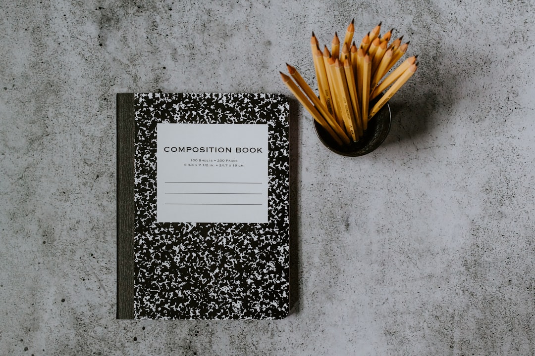 black and white book on gray marble table, Comp book and #2 pencils in a cup
