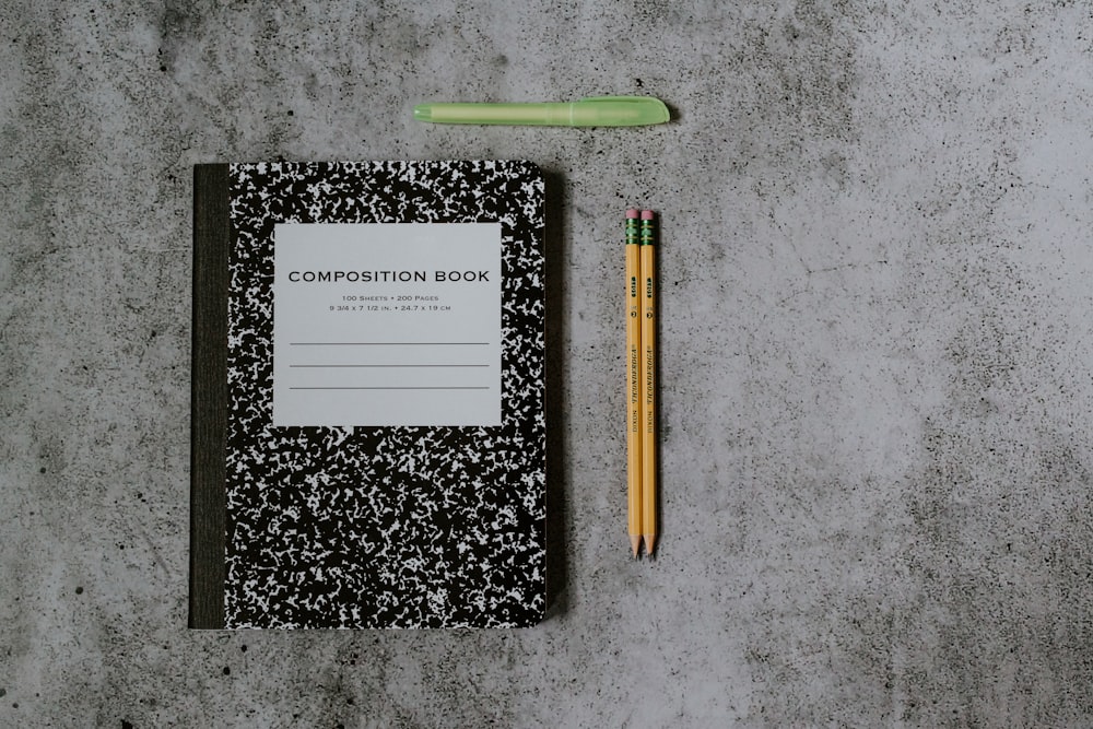 black and white book beside brown pencil