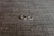 Two rings are placed side by side on a textured grey fabric surface. One ring is a plain band, while the other appears to have a row of small stones or diamonds.