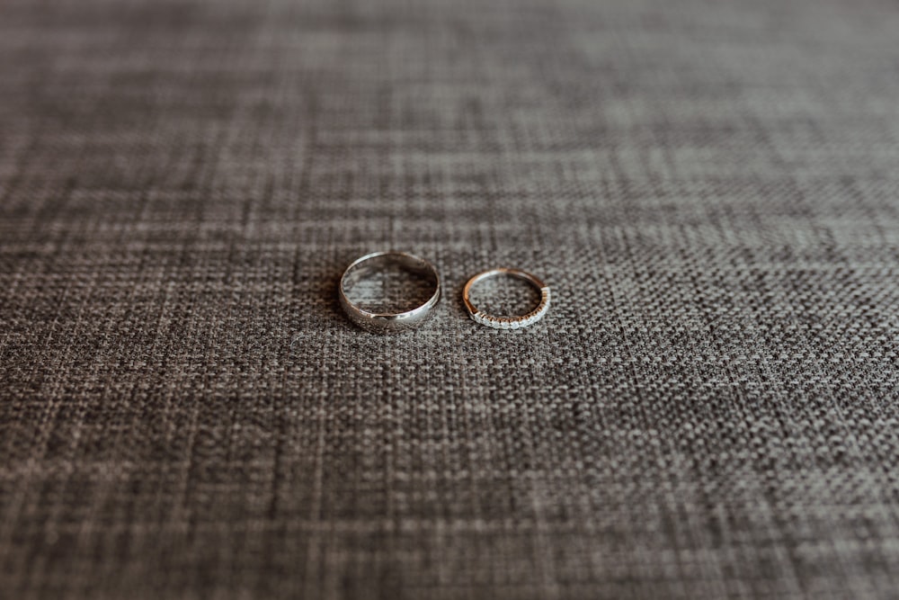 silver wedding band on gray textile