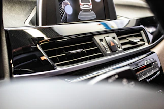 A sleek black and silver car dashboard with a glowing phone icon indicating contact.