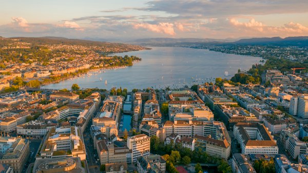 Aerial view of city buildings near body of water during daytime — Zurich, Switzerland