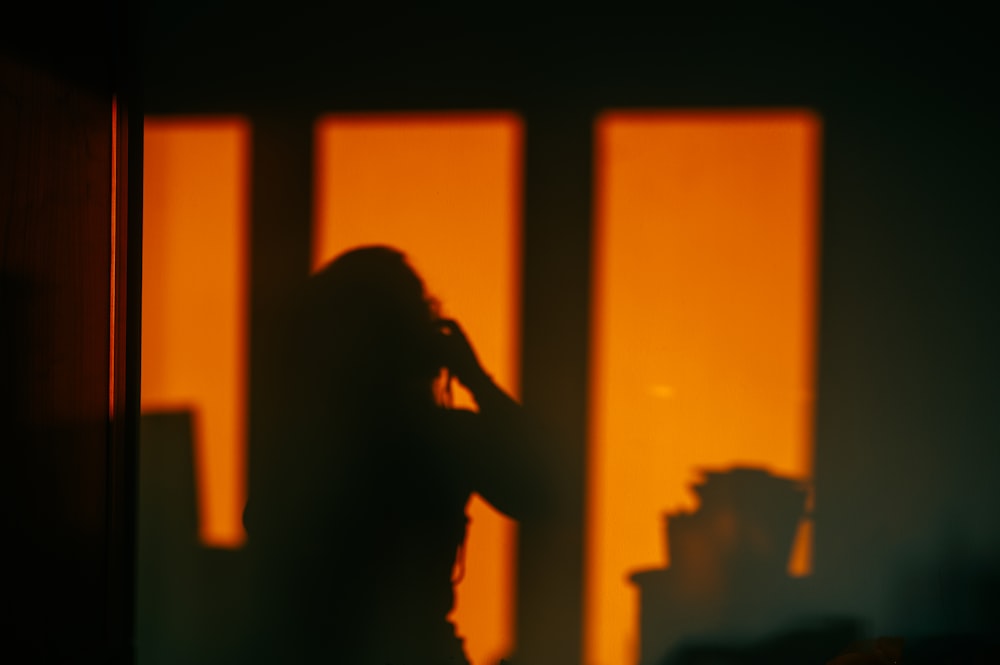 silhouette of woman standing near window