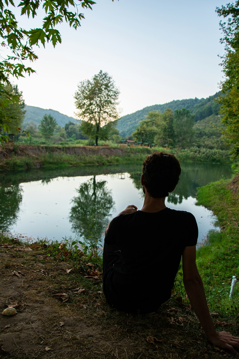 man in black crew neck t-shirt standing near lake during daytime