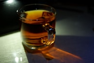 Warm, golden light illuminating a quiet moment of journaling beside a steaming cup of herbal tea.