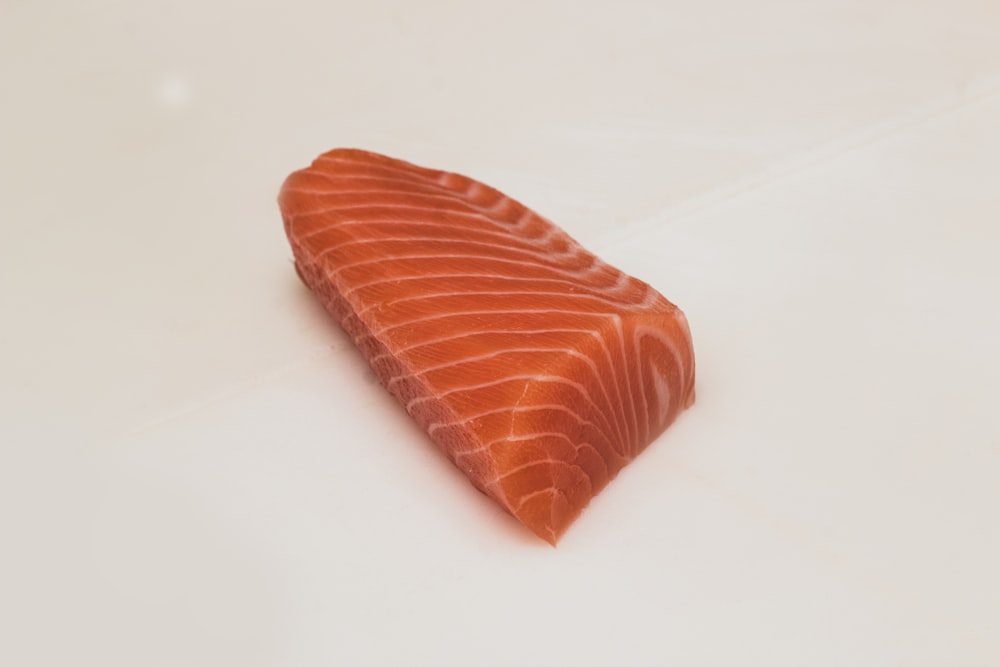 carne de peixe fatiada na superfície branca