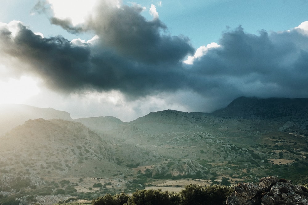 Des arbres verts et des montagnes sous des nuages blancs