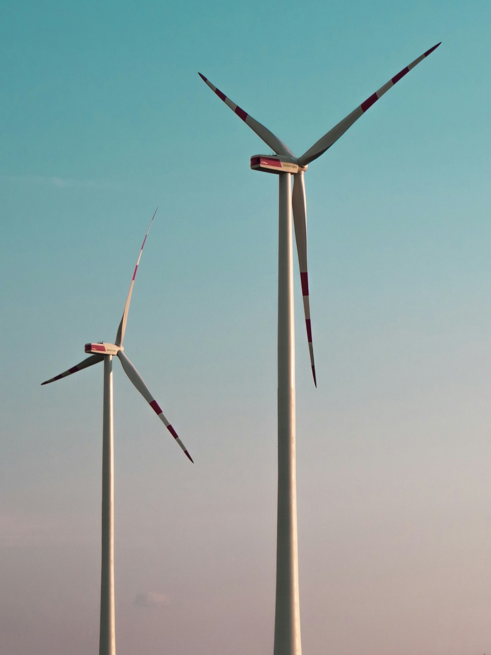 white wind turbine under blue sky during daytime