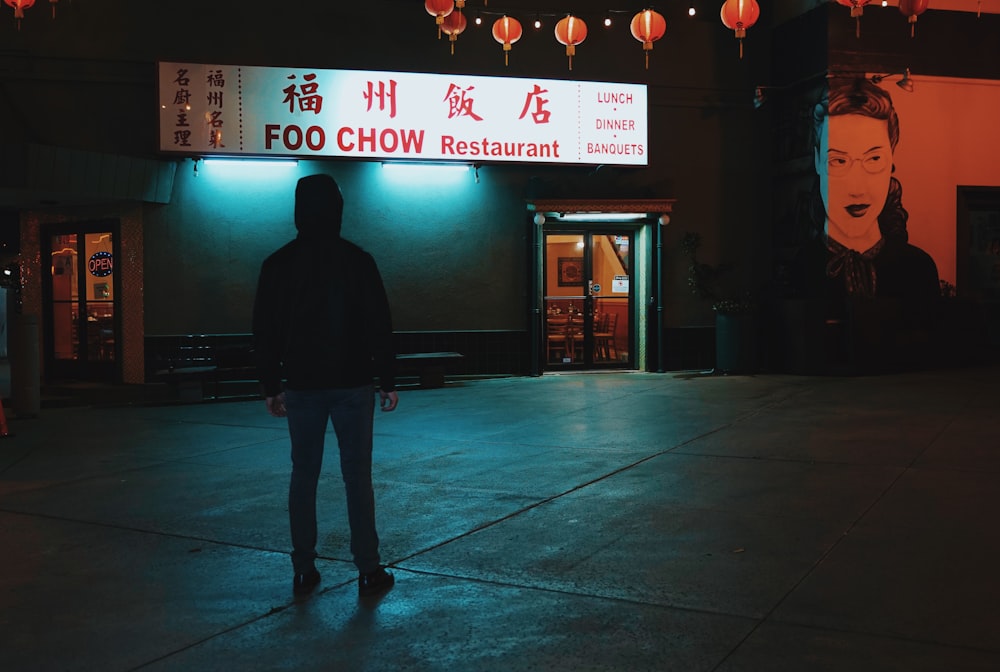 man in black jacket standing near store