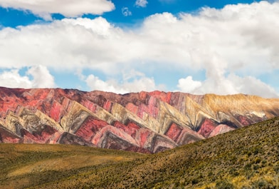 brown and gray mountains under white clouds and blue sky during daytime