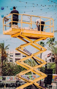 man in black t-shirt and black pants riding yellow and black roller coaster during daytime