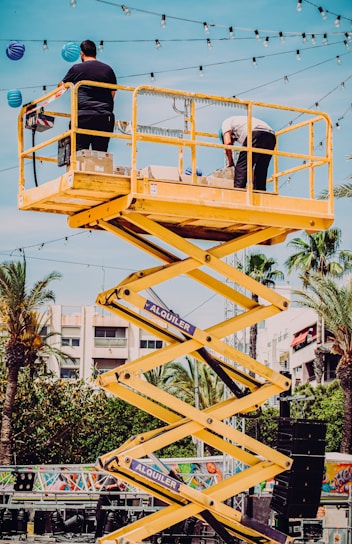 man in black t-shirt and black pants riding yellow and black roller coaster during daytime