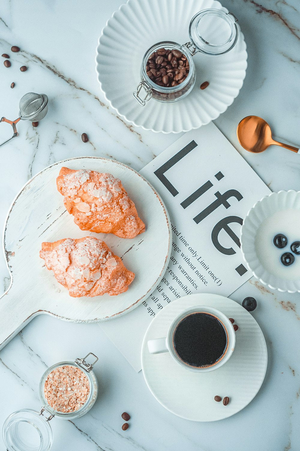 white ceramic mug beside stainless steel spoon