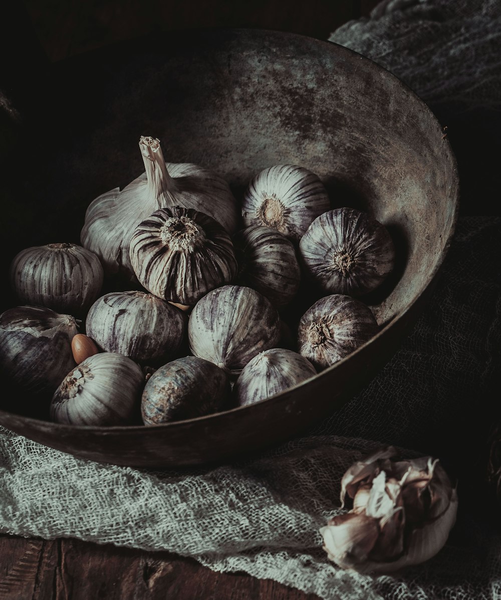 brown and white round fruits in black bowl