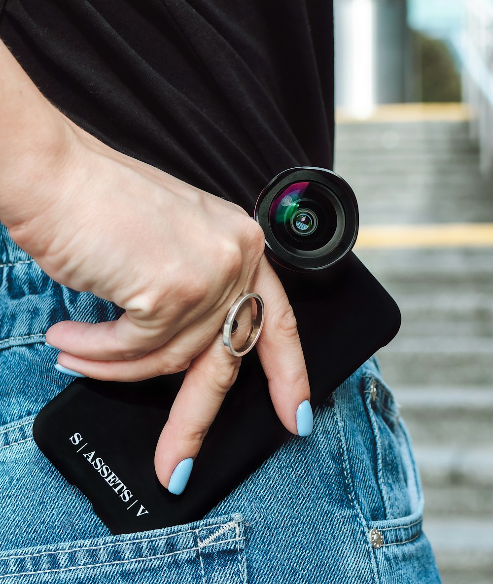 person holding black nikon camera lens