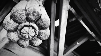 A rustic wooden craft piece with detailed carvings resting on a textured fabric.