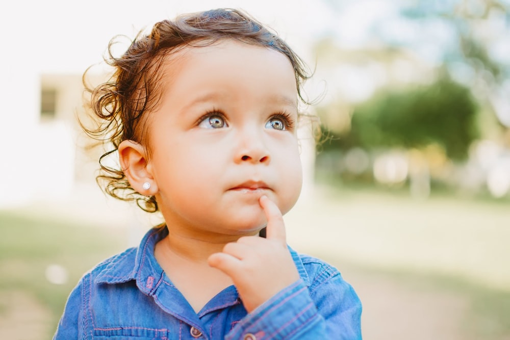 child in blue denim button up shirt