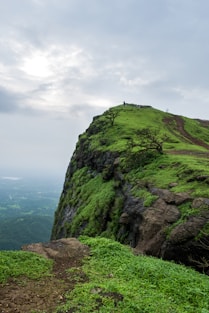 green and gray rock formation under white clouds during daytime