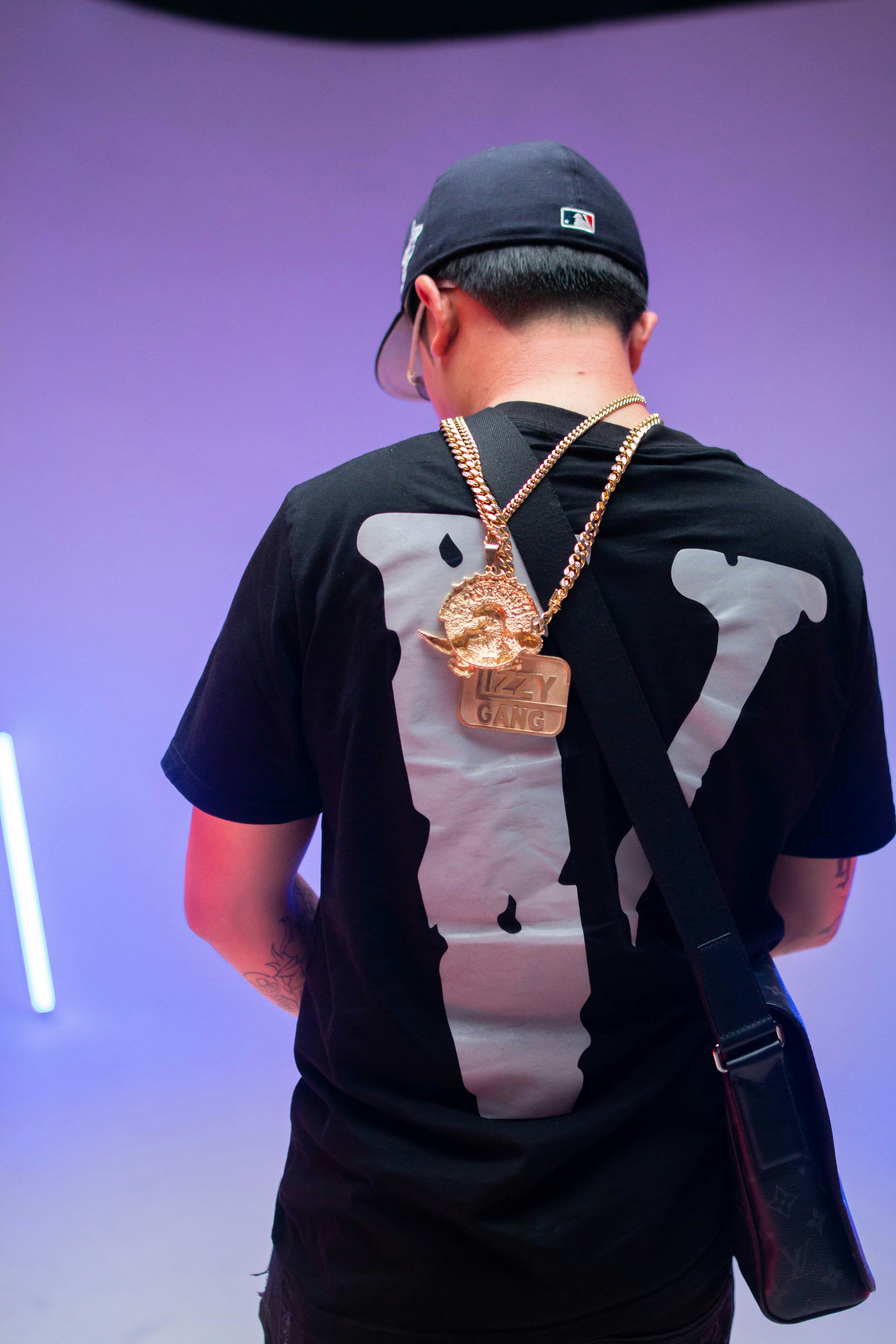 man in black crew neck t-shirt wearing gold necklace