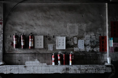 Fire extinguisher display with various types and sizes arranged on a clean showroom shelf.