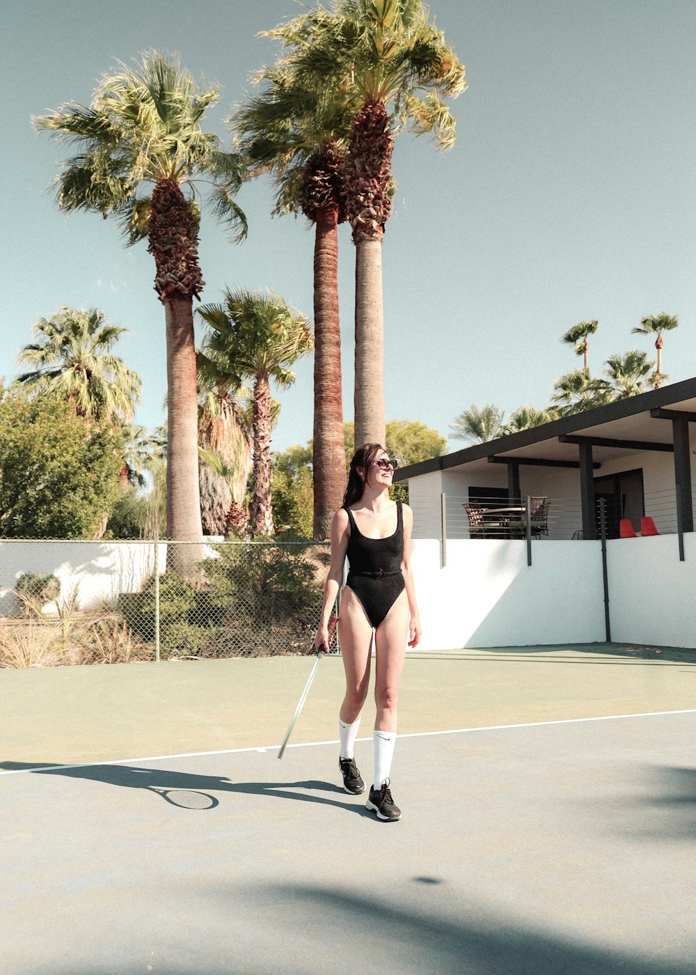 woman in black sports bra and black shorts standing on white basketball court during daytime