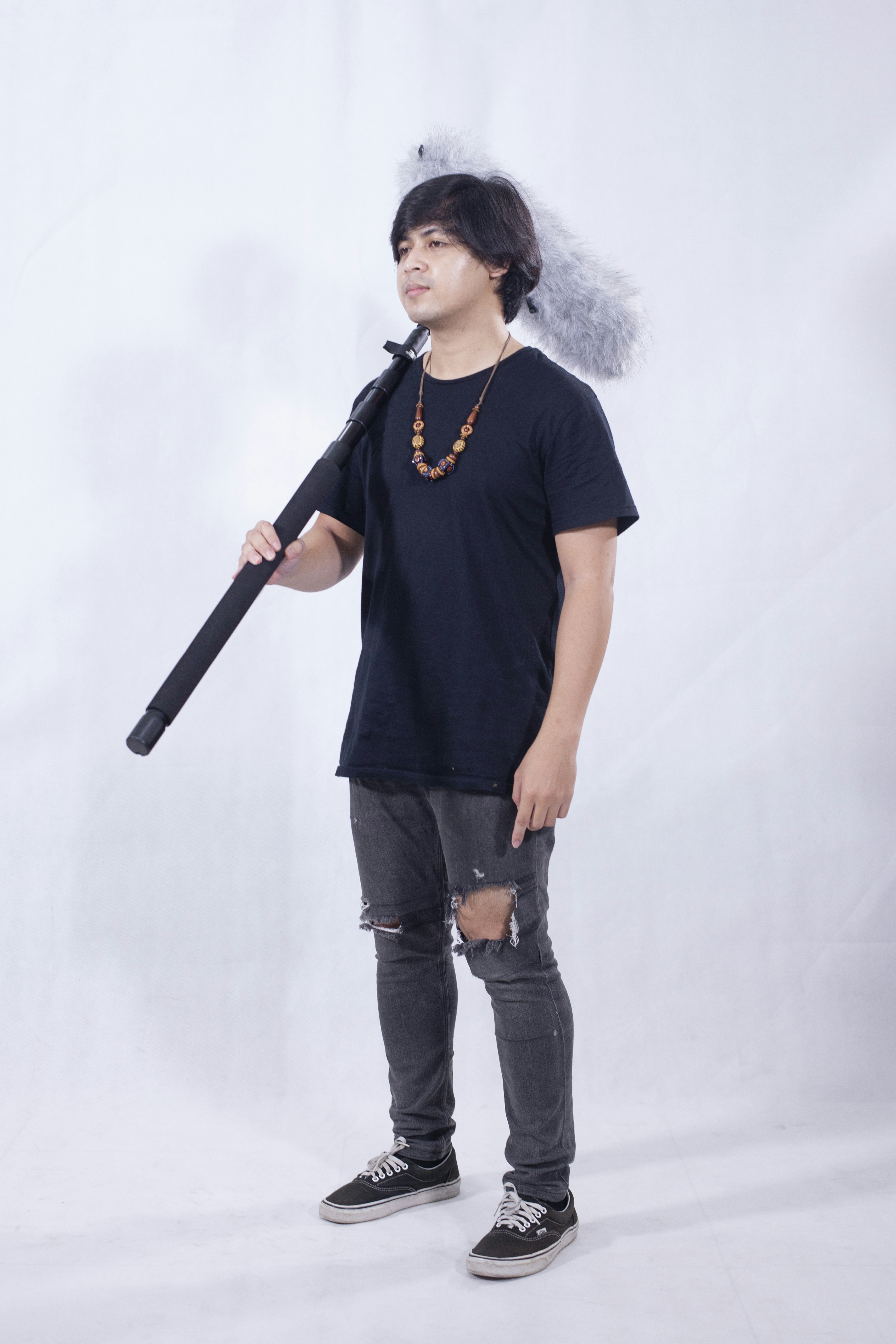 Pria berbaju leher kru hitam memegang mikrofon hitam