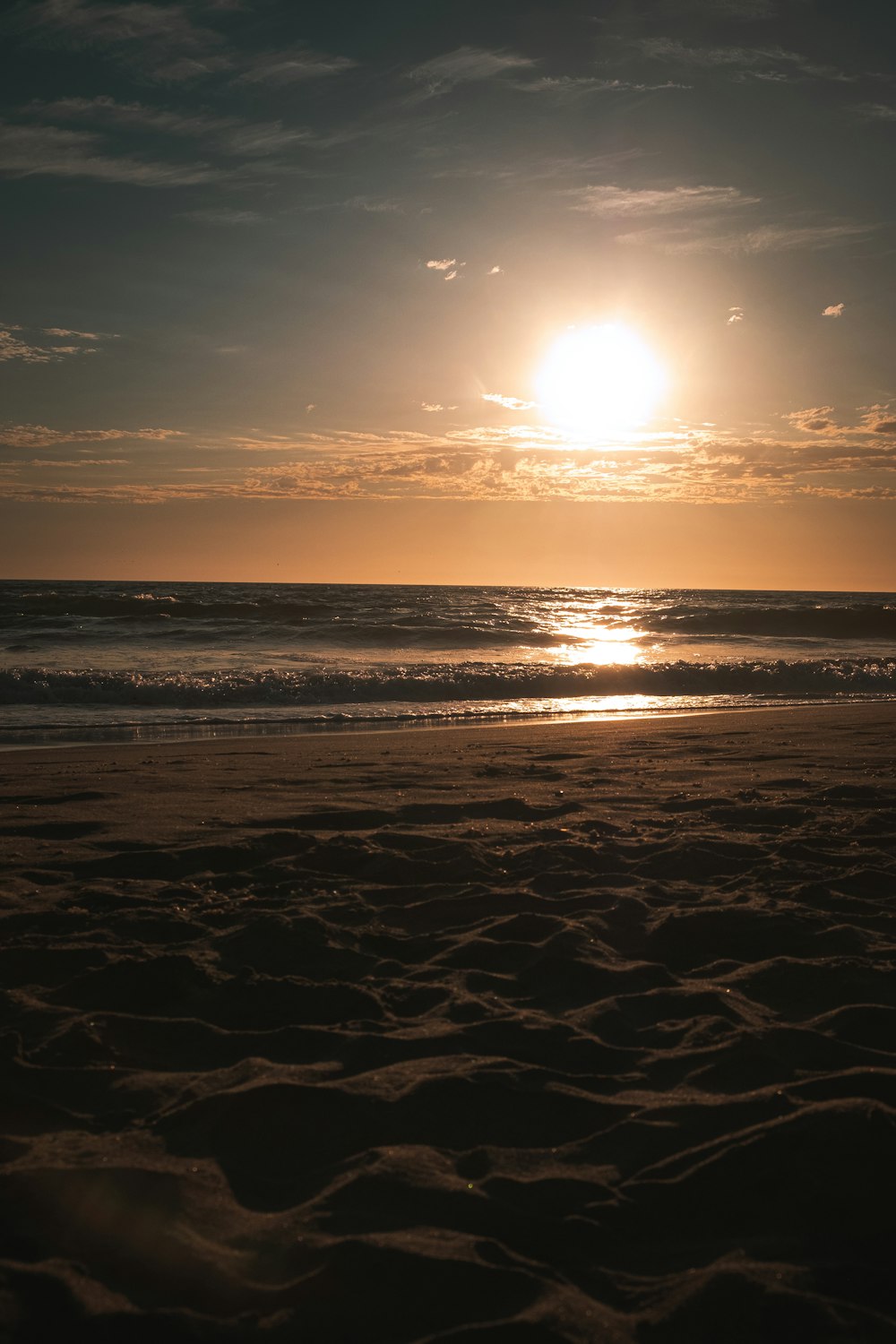 sea waves crashing on shore during sunset