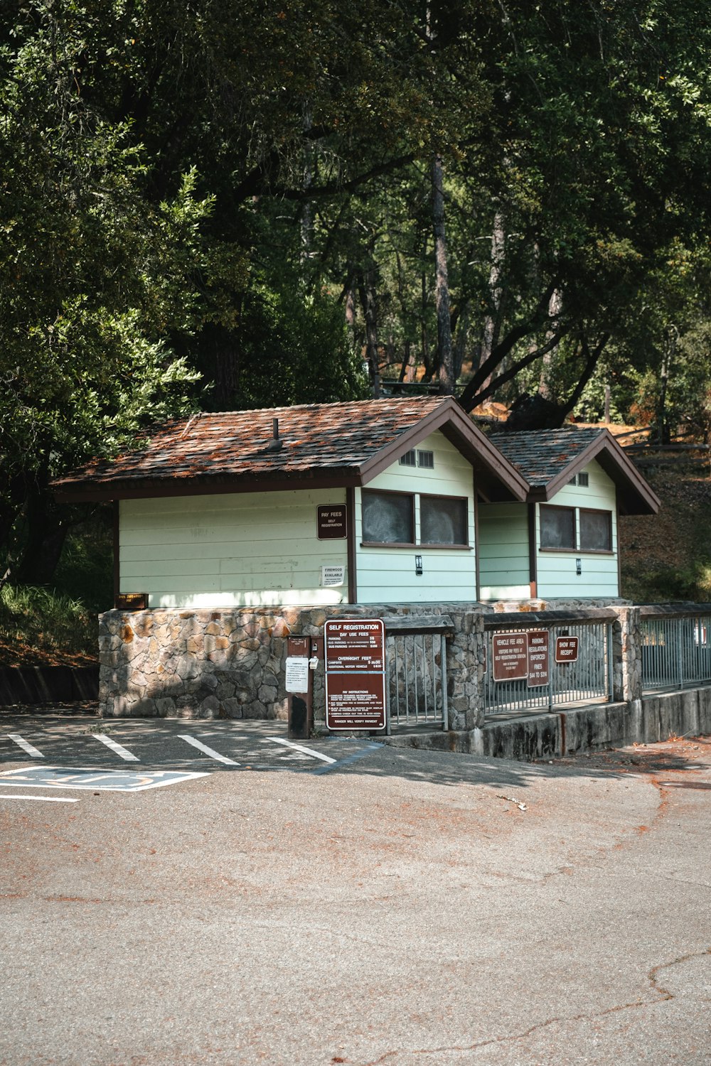 white and brown wooden house near green trees during daytime