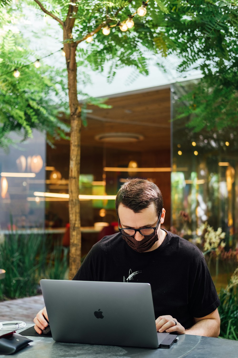 man in black crew neck shirt using macbook