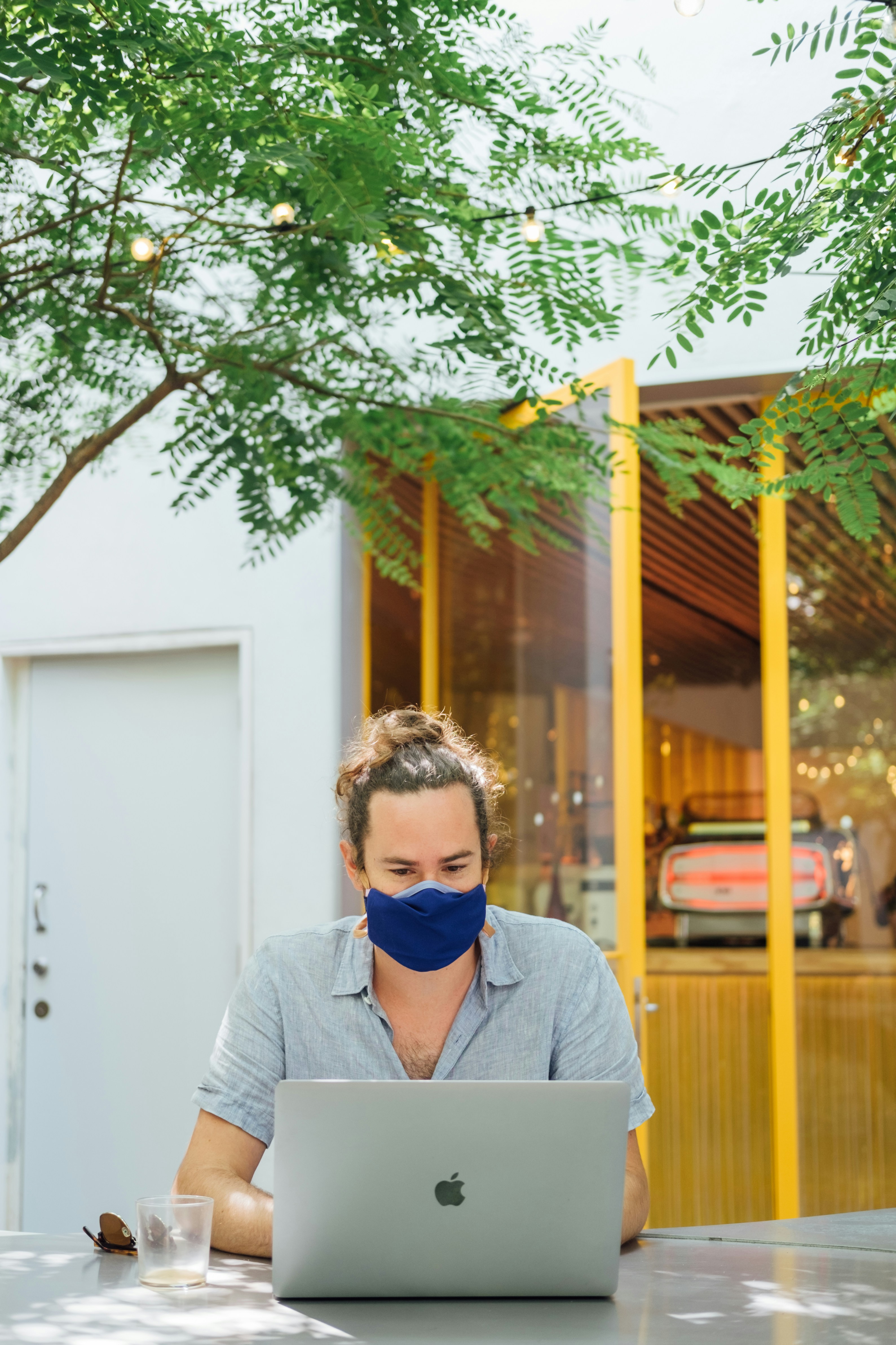 Hombre con chaqueta de traje gris con gafas de sol azules