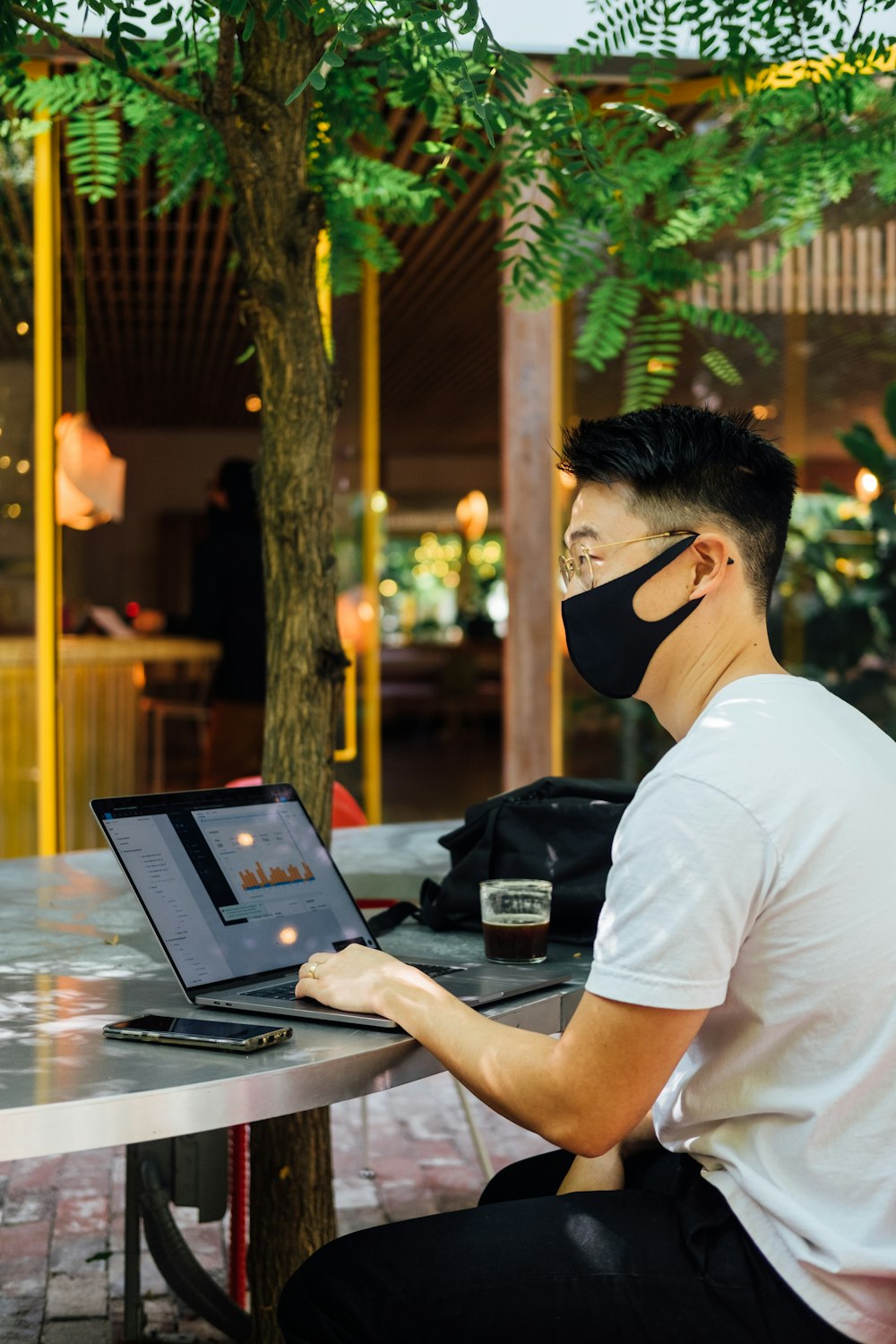 man in white t-shirt using laptop computer