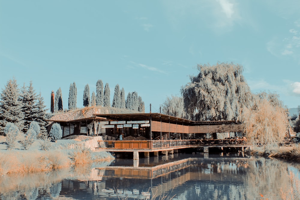 brown wooden house near body of water during daytime