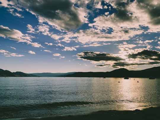 body of water under blue sky and white clouds during daytime in Kelowna Canada